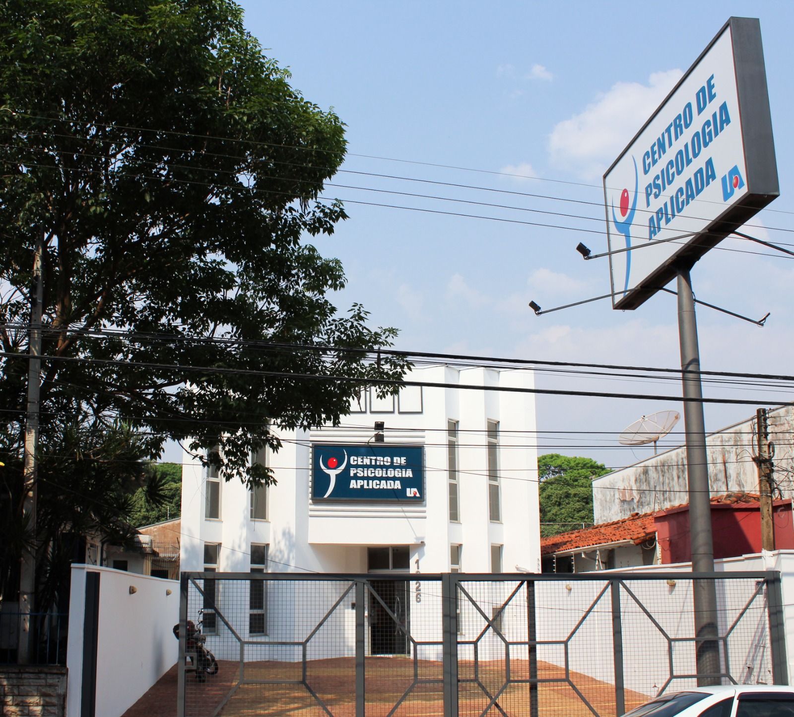 Prédio branco do Centro de Psicologia Aplicada da Uniara, com placa azul na fachada e portão de grade na frente