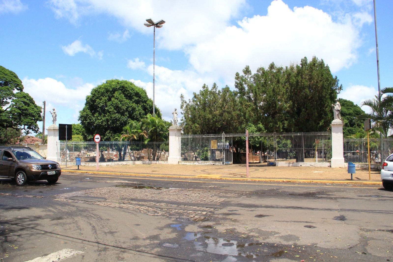 Entrada de cemitério municipal de Araraquara, com grade e colunas brancas com estátuas