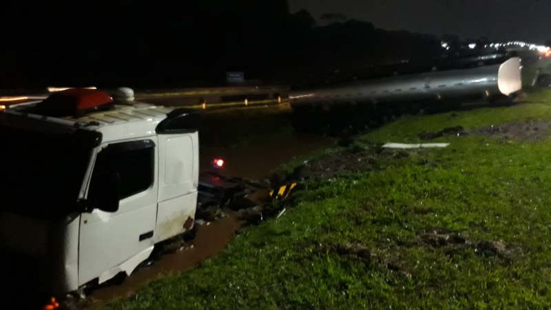 Motorista fica ferido após caminhão com combustível rodar na pista e cair em canaleta