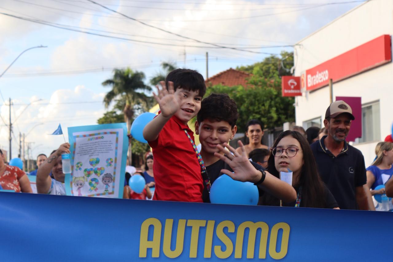 Famílias participaram da caminhada com cartazes e balões azuis, símbolo da conscientização sobre o autismo.