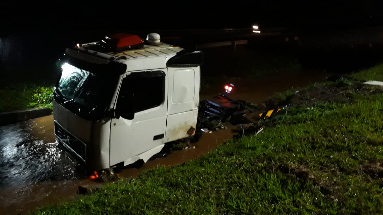 Foto 2 de 2 — Motorista fica ferido após caminhão com combustível rodar na pista e cair em canaleta